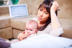 Mother Holding Baby While Working From Home